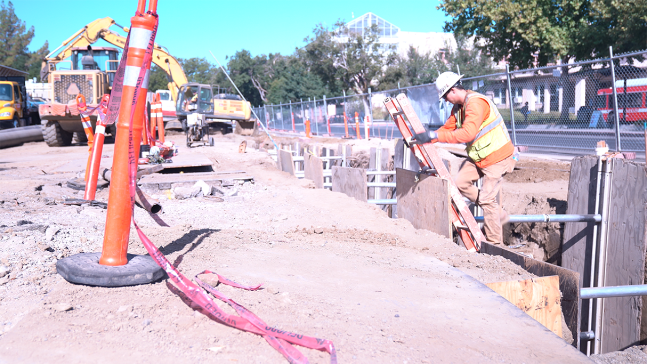 Image of contractor climbing out of a trench.