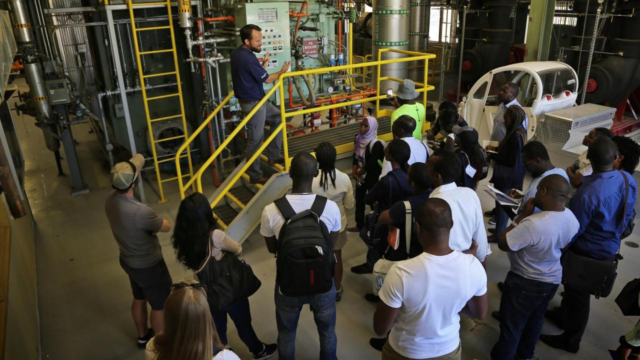 Joshua Moorejohn showing a boiler on a facilities tour