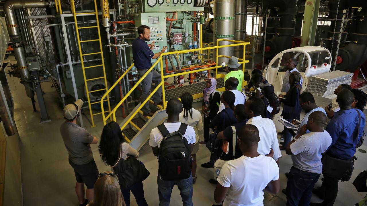 Joshua Moorejohn showing a boiler on a facilities tour
