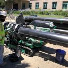Man standing by a machine fusing two sections of pipe together